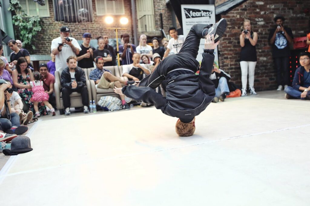 a man dancing and covered by a crowd of people